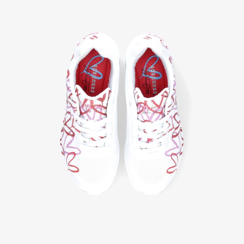 Weiße Sneaker mit roten Akzenten und Musterung, stilvoll und komfortabel für sportliche Aktivitäten.