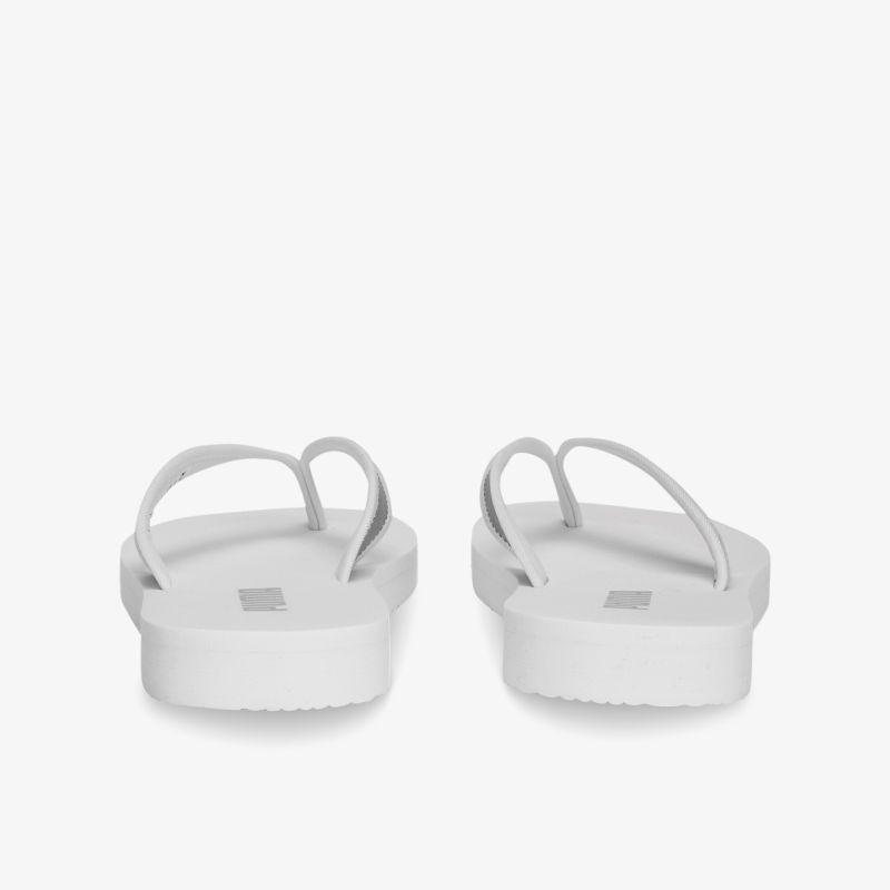 Weiße Flip-Flops mit ergonomischer Sohle und minimalistischen Trägern für optimalen Komfort.