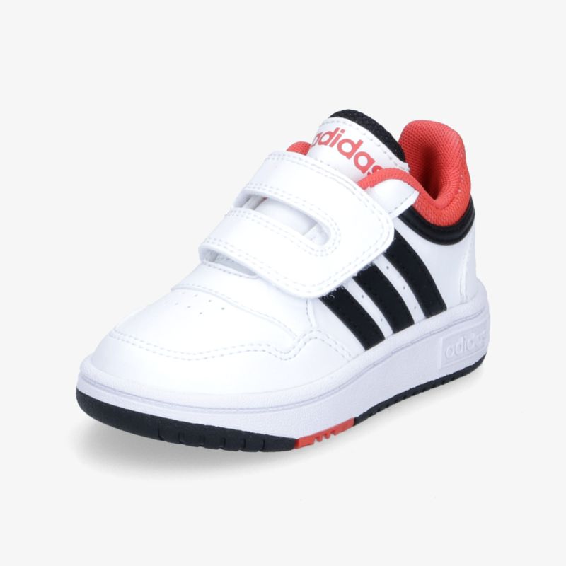 Bequemer weißer Turnschuh mit Klettverschluss und markanten schwarzen Streifen, ideal für Alltag und Freizeit.