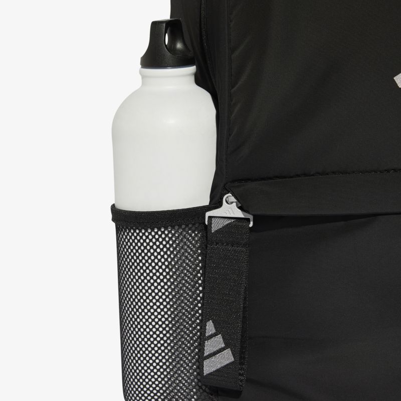 Weißer Trinkflasche im seitlichen Netzfach eines schwarzen Rucksacks, leicht zugänglich und sicher verstaut