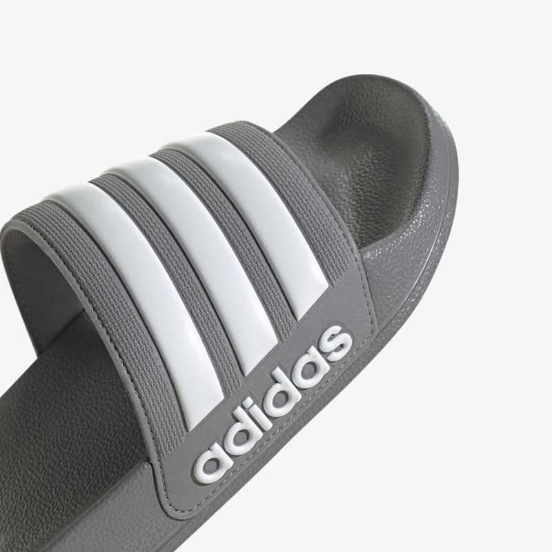 Bequeme graue Riemensandale mit weißem Logo und Streifen, ideal für Alltag und Freizeit.