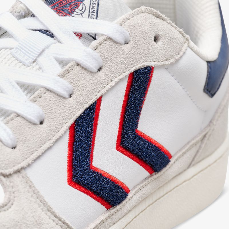 Weiße Turnschuhe mit rotem und blauem Design, hochwertig verarbeitet für stylischen Auftritt.