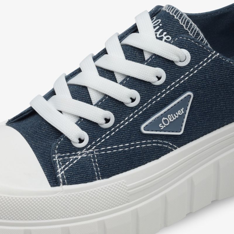 Detailaufnahme eines blauen Sneakers mit weißen Schnürsenkeln und auffälliger robuster Sohle