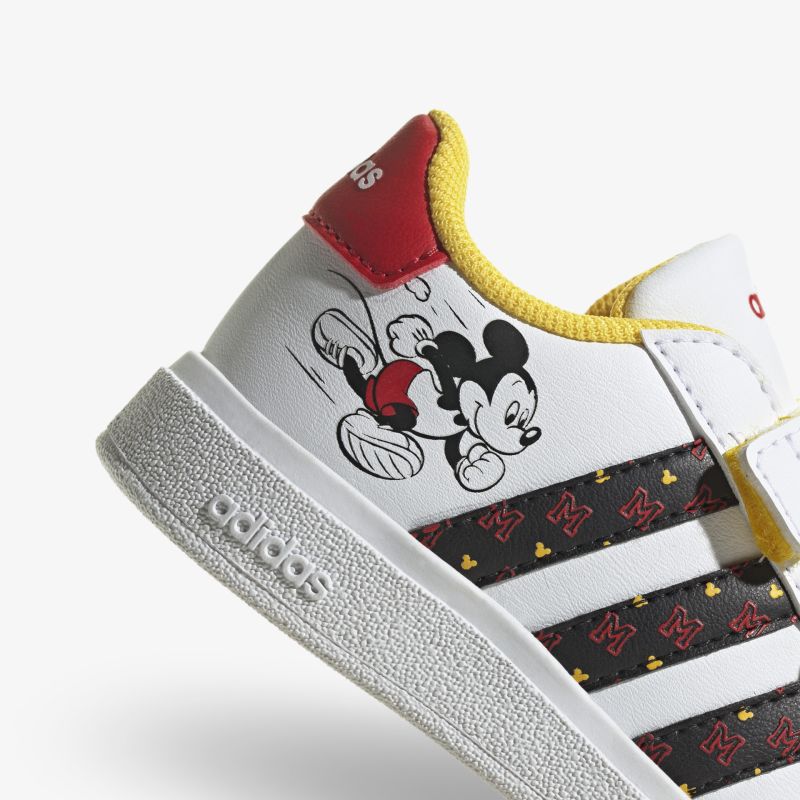 Stylischer adidas Sneaker mit Mickey Mouse Motiv für Kinder. Auffälliges Design mit gelben und roten Akzenten.