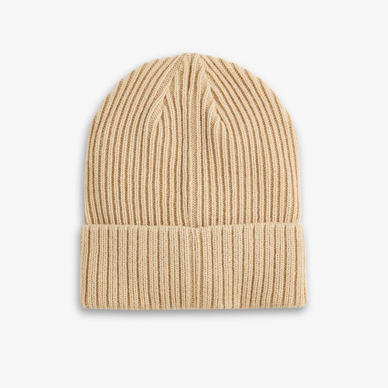 Vielseitige Beanie aus weichem Rippstrick in Beige, perfekt für kalte Wintertage.