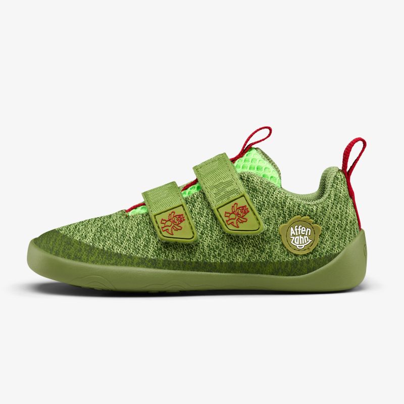 Grüner Sportschuh mit Klettverschluss und markantem Design, seitliche Ansicht