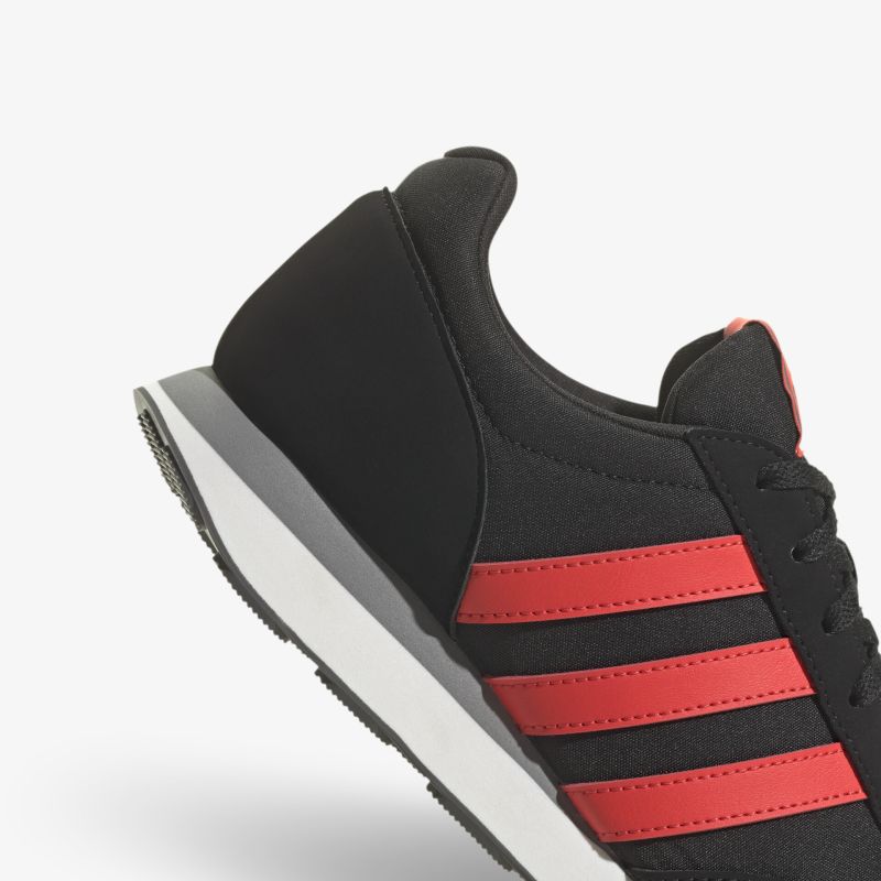 Moderner schwarzer Sneaker mit roten Streifen und schlichter Sohle für vielseitige Outfits.