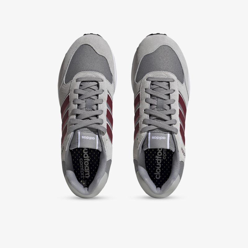 Graue Sneaker mit roten Details, ideal für sportliche Aktivitäten und Alltag, bieten hohen Tragekomfort und Stil.