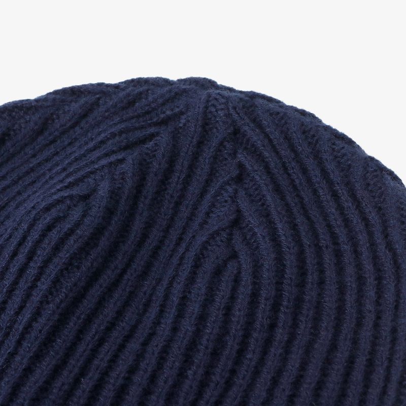 Detailaufnahme einer Dunkelblauen Strickmütze mit weichem Rippstrickmuster, ideal für kalte Tage.