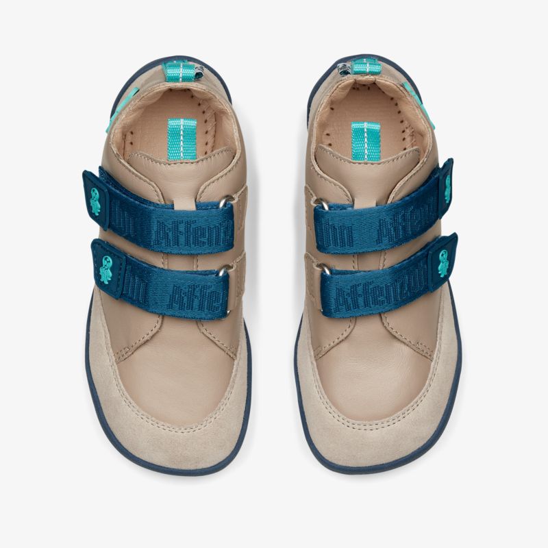 Beige Schuhe mit doppeltem Klettverschluss für optimalen Halt und komfortable Passform bei jedem Schritt.