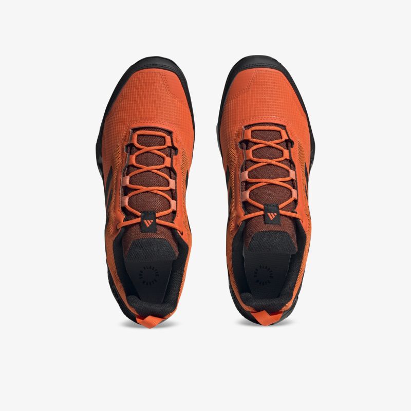 Orangefarbene, robuste Halbschuhe mit verstärkter Sohle und atmungsaktiver Materialstruktur, ideal für Outdoor-Aktivitäten.