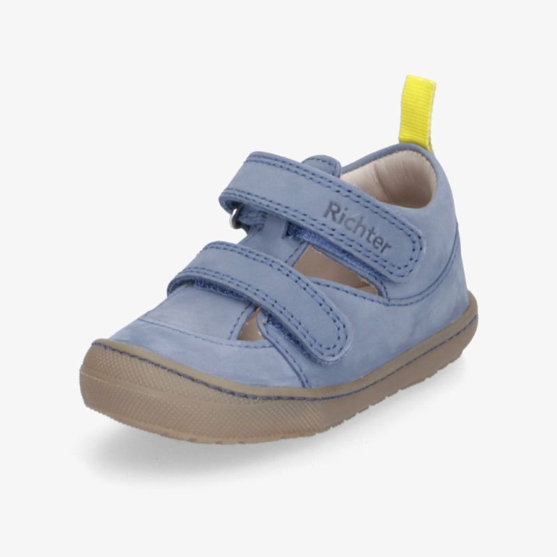 Blauer Kinderschuh mit gelbem Zugband, weiches Material, flexible rutschfeste Sohle und zwei verstellbare Klettverschlussriemen.