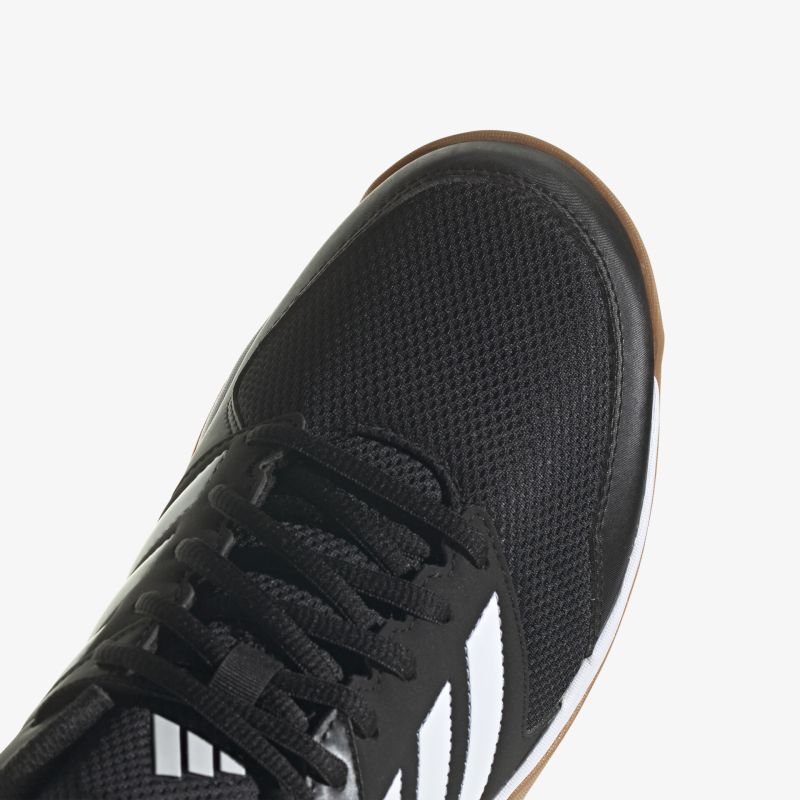 Moderner schwarzer Sportschuh mit weißen Streifen, rutschfeste Sohle und atmungsaktives Obermaterial.