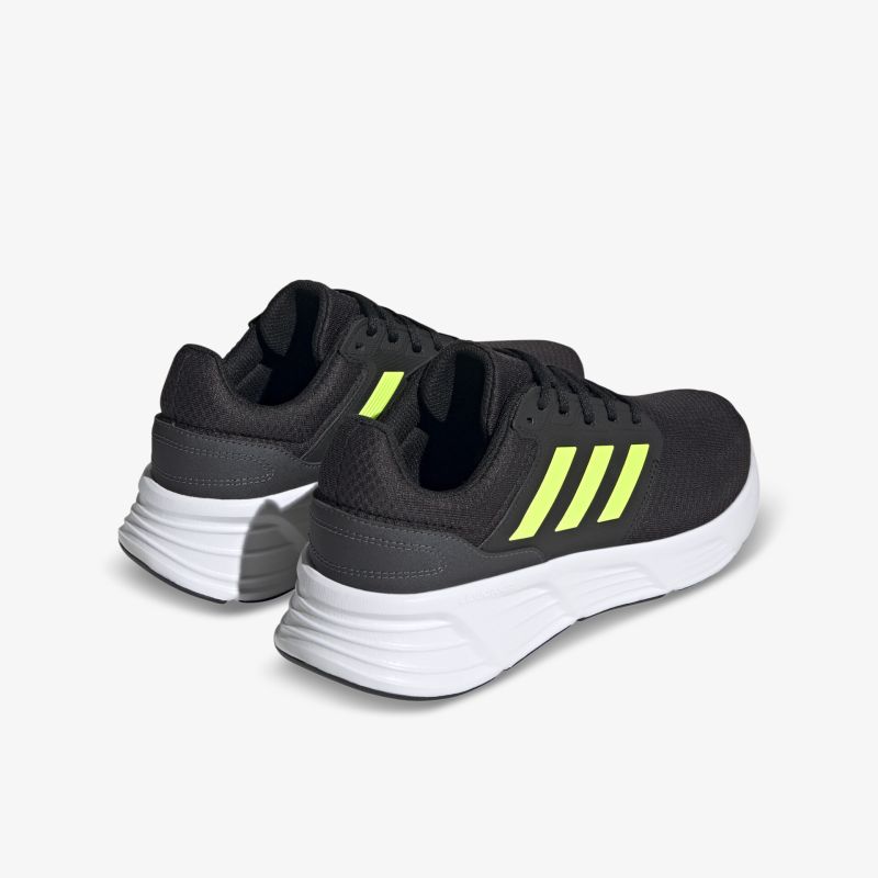 Moderne schwarze Turnschuhe mit leuchtend gelben Streifen und weißer Sohle für optimalen Komfort und Stil.