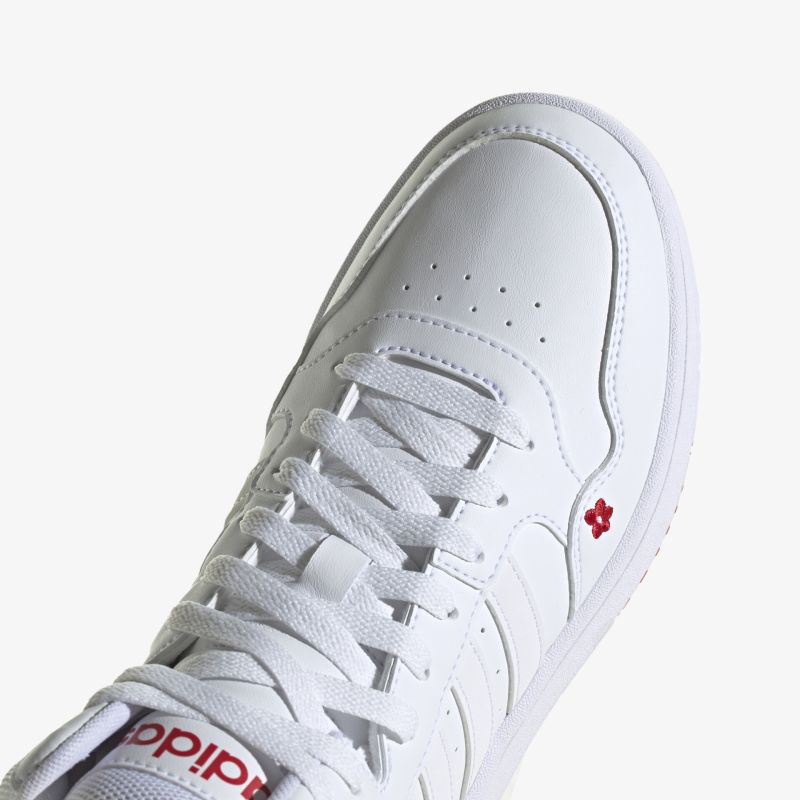 Stilvoller weißer Sneaker mit roten Akzenten und rutschfester Sohle für optimalen Tragekomfort.