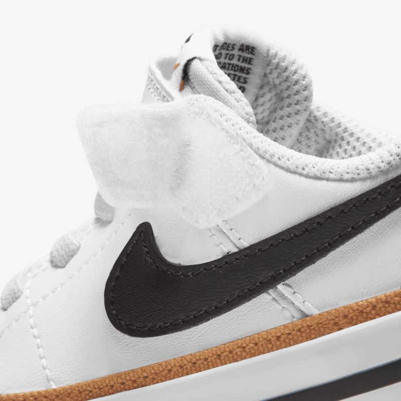 Weißer Sneaker mit schwarzem Nike-Logo, seitliche Ansicht, sportliches Design und präzise Verarbeitung