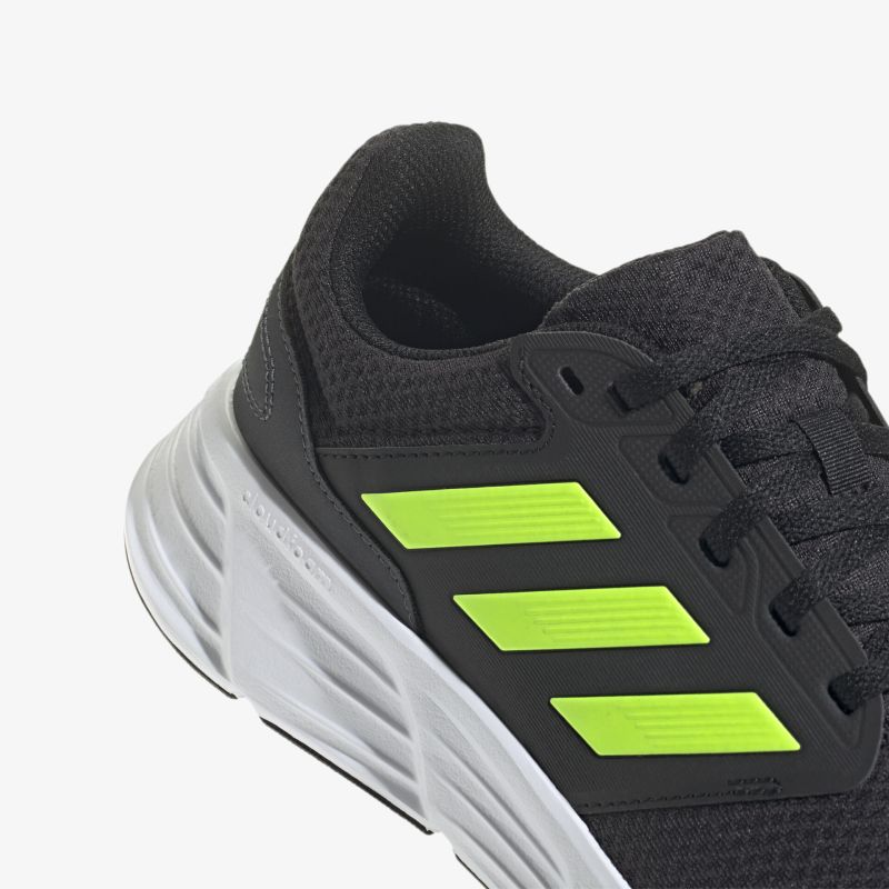 Moderner Sneaker in Schwarz mit auffälligen neongelben Akzenten und robustem Design für hervorragenden Tragekomfort.