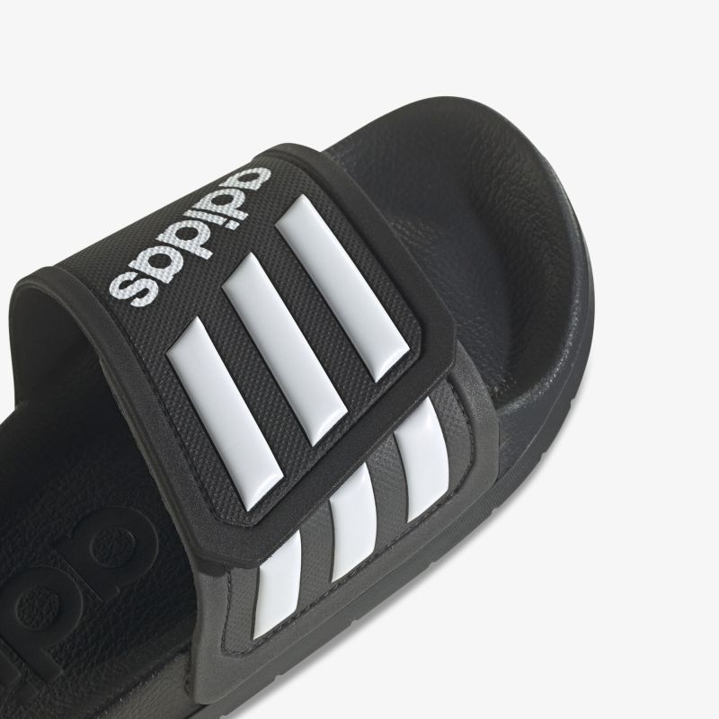 Bequeme schwarze Sandale mit verstellbarem Riemen und markanten weißen Streifen.