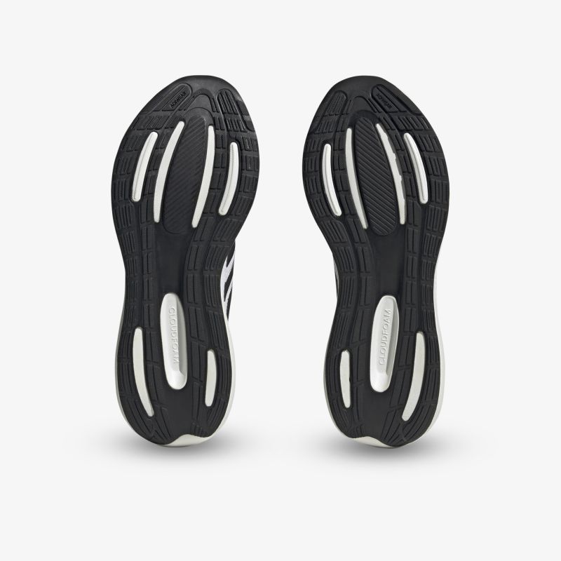 Schwarze Sohlen eines Sportschuhs mit weißen Details, optimal für Halt und Performance.