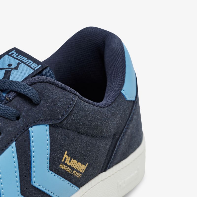 Moderner Hummel Schuh mit blauem Akzent und bequemem Sitz, ideal für sportliche Anlässe.