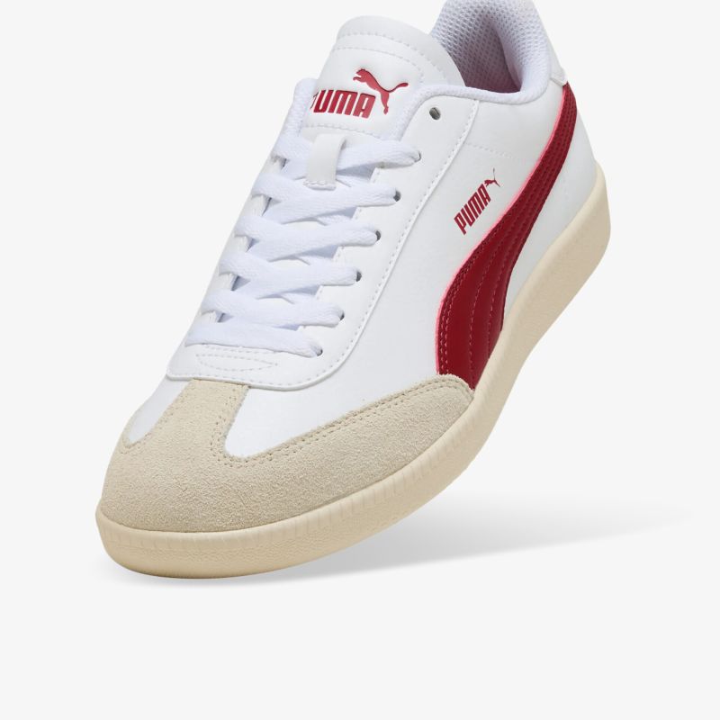 Schräg vorne Ansicht eines weißen Puma Sneakers mit rotem Logo und beigefarbener Sohle