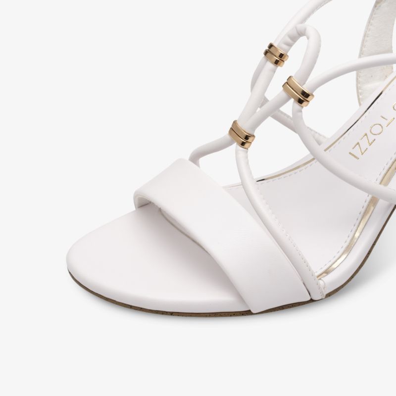 Detailaufnahme einer weißen Sandale mit feinen Riemen und goldenen dekorativen Akzenten