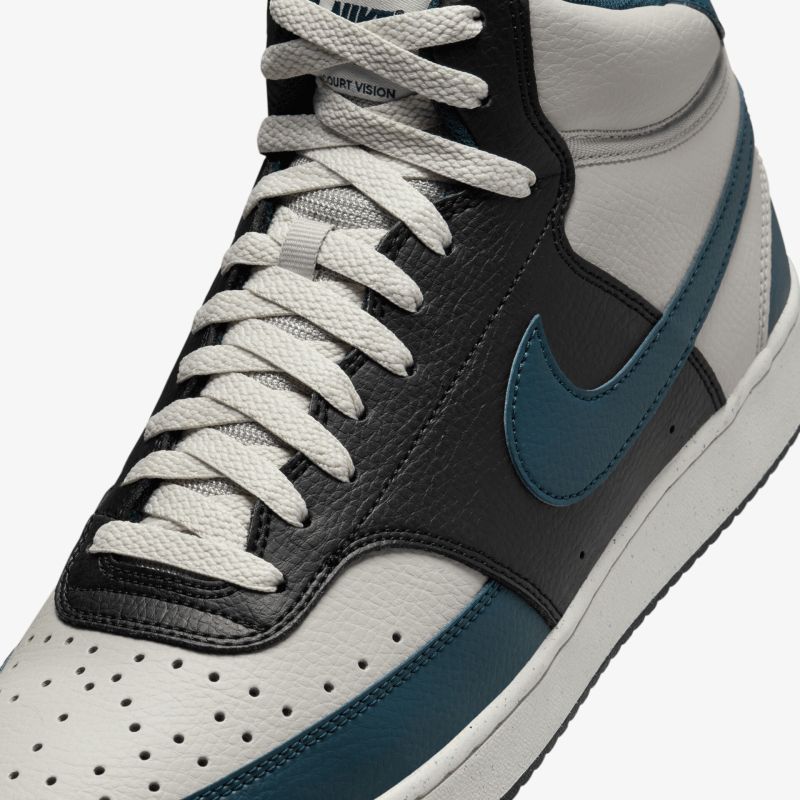Detailaufnahme eines hochwertigen Sneakers mit robuster Schnürung und kontrastreichem modischem Design in schwarz, grau und blau