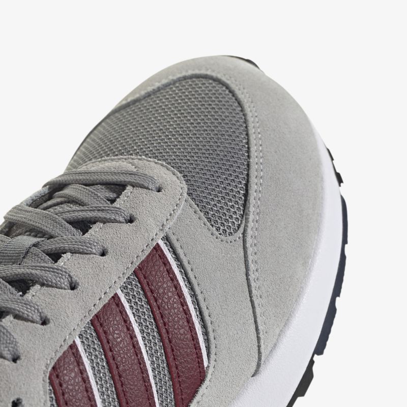 Moderner Sneaker mit grauem Mesh und roten Streifen, ideal für sportlichen Komfort in der Freizeit.