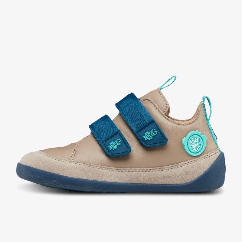 Beiger Sneaker mit blauem Klettverschluss und rutschfester Sohle für Alltag und Abenteuer.