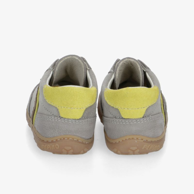 Rückansicht von bequemen Schuhen in Grau mit gelbem Fersenbereich und rutschfester brauner Sohle