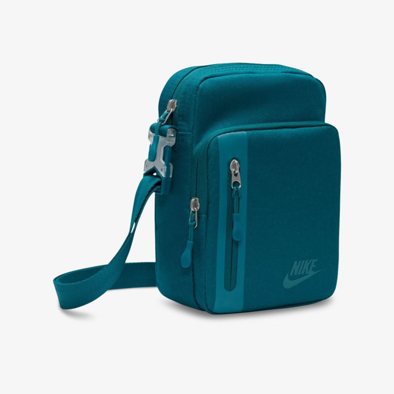 Kompakte türkise Schultertasche mit mehreren Reißverschlussfächern und verstellbarem Gurt, ideal für Alltag und Reisen.