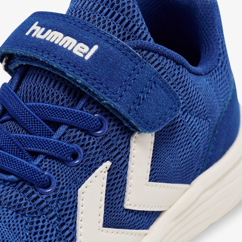 Detailaufnahme eines blauen Sportschuhs mit weißem Logo und Klettverschluss für optimalen Halt und Komfort