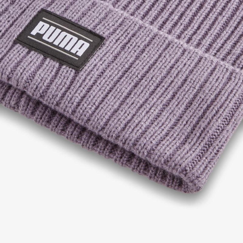 Detailaufnahme einer lila Strickmütze mit klar sichtbarem Puma Markenlogo und fein gestrickter Struktur