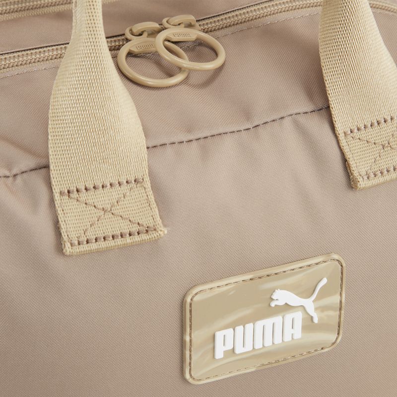 Detailaufnahme des robusten Tragegriffs und PUMA Logos an strapazierfähiger Tasche in neutralem Farbton