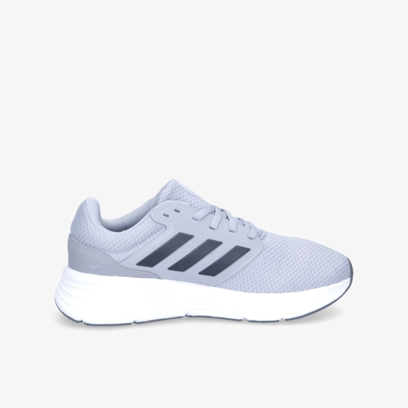 Graue Sneakers mit weißer Sohle und markanten Streifen, ideal für sportliche Aktivitäten und täglichen Komfort.