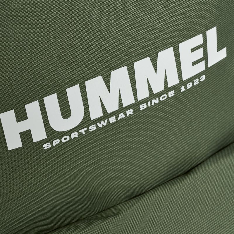 Hummel Sportswear Logo auf olivgrünem Stoff nah aufgenommen, klare Schrift und feine Stoffstruktur sichtbar