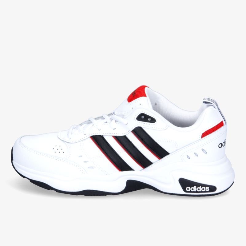 Weißer Turnschuh mit markanten schwarzen Streifen und rotem Detail, seitliche Ansicht.