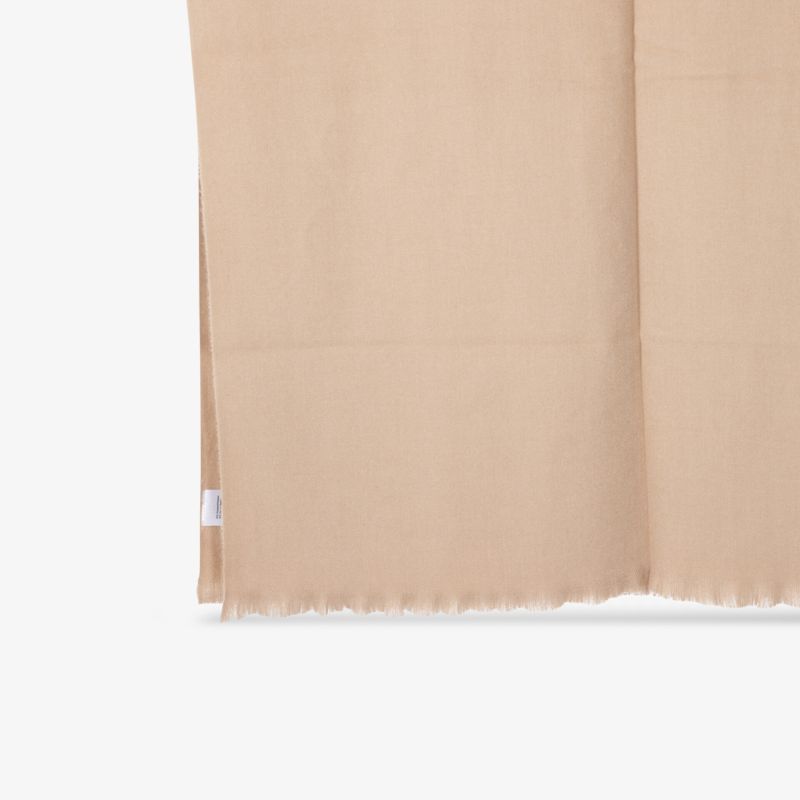 Weicher, beiger Stoff mit feiner Textur und eleganten Fransen.