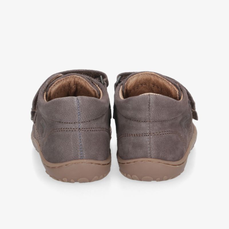 Rückansicht von braunen Schuhen mit robustem Design und Klettverschluss für sicheren Halt und Komfort.