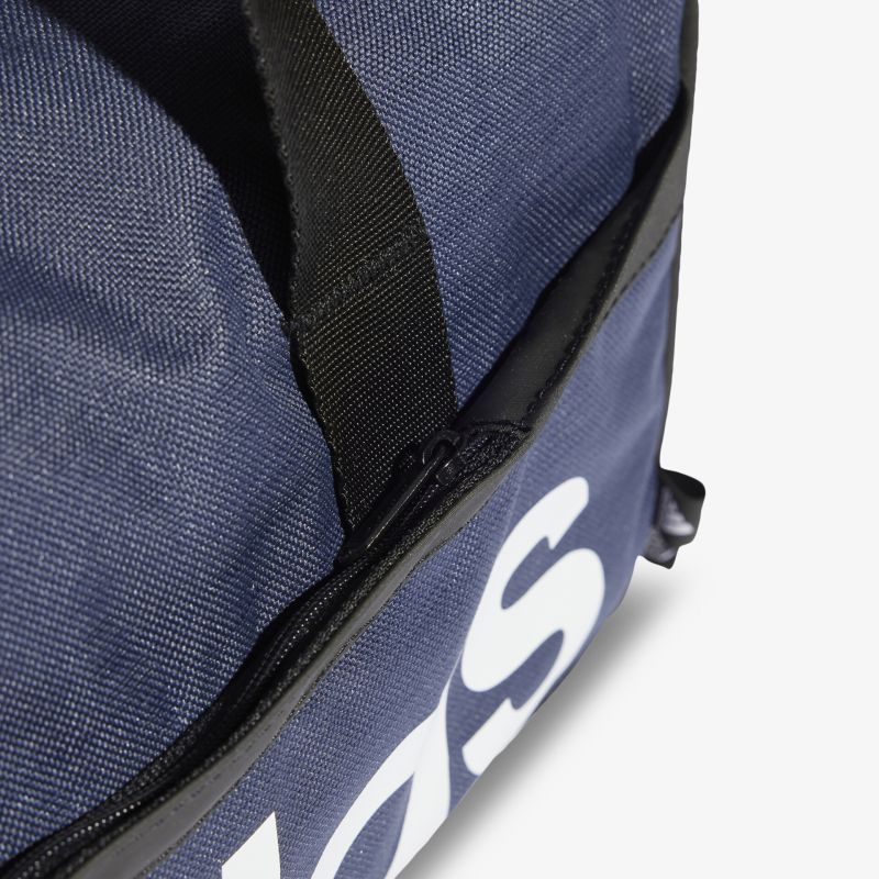 Detailaufnahme einer blauen Sporttasche mit schwarzem Griff und großem weißen Logo