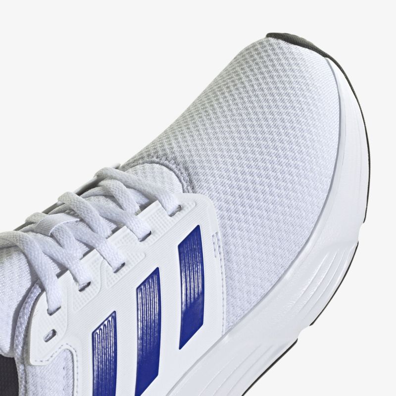 Sportlicher Sneaker mit atmungsaktivem weißen Mesh-Obermaterial und blauen Akzenten für modernen Style.
