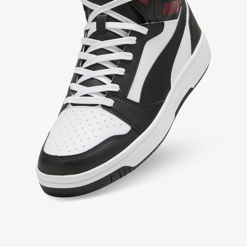 Detailaufnahme eines schwarzen und weißen Sneakers mit hochwertiger Schnürung und perforiertem Leder
