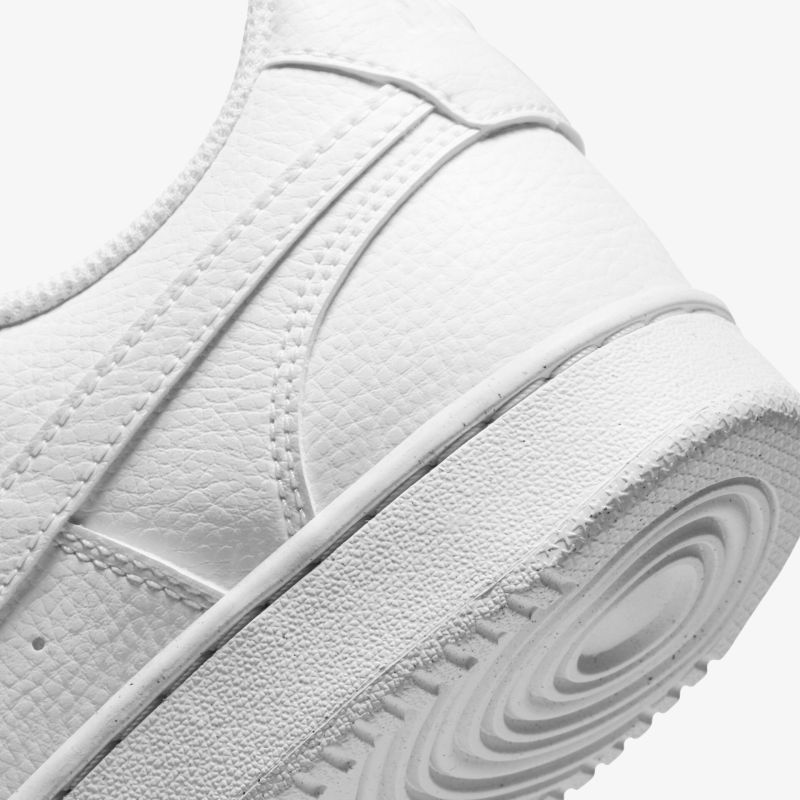 Detailansicht eines stilvollen weißen Sneakers in Lederoptik mit strukturierter Sohle.