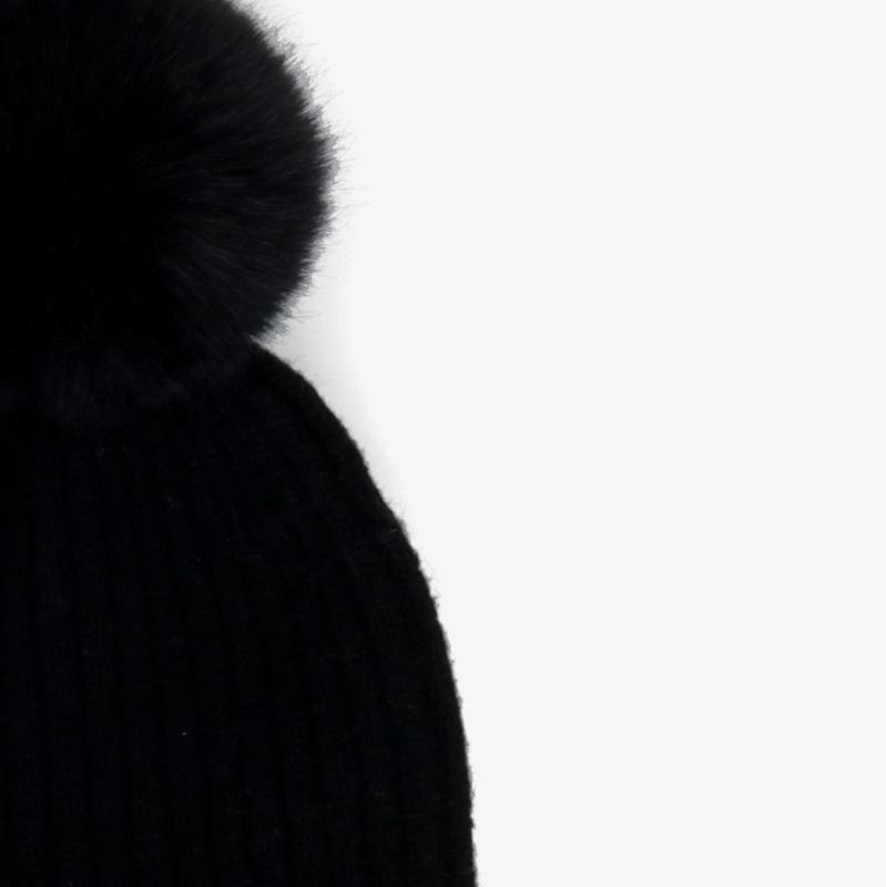 Elegante schwarze Strickmütze mit Bommel für stilvolle Wärme an kalten Tagen.