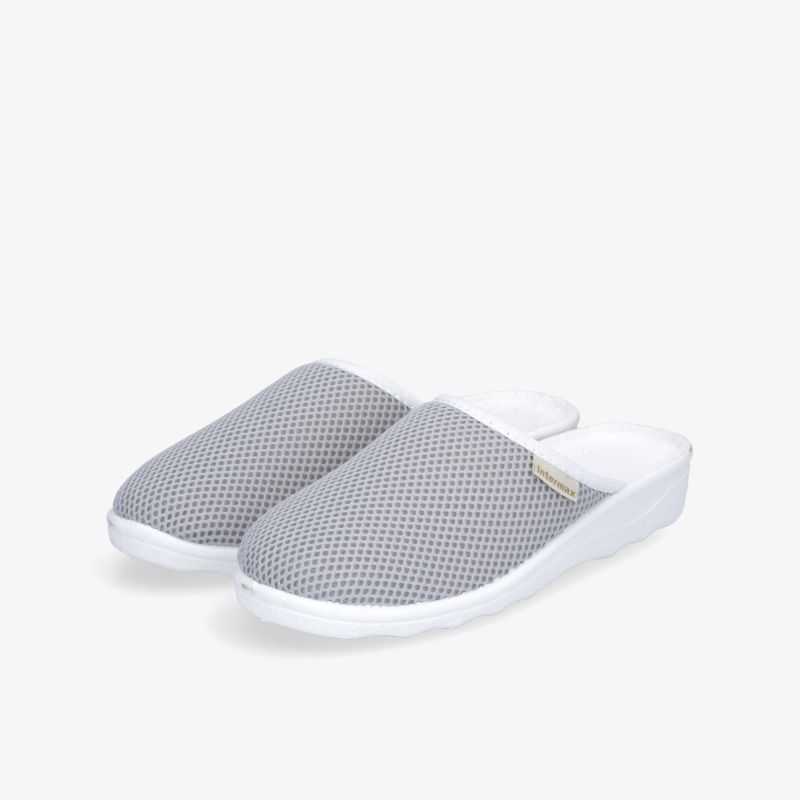 Bequeme graue Hausschuhe mit atmungsaktivem Mesh-Obermaterial und rutschfester Sohle.