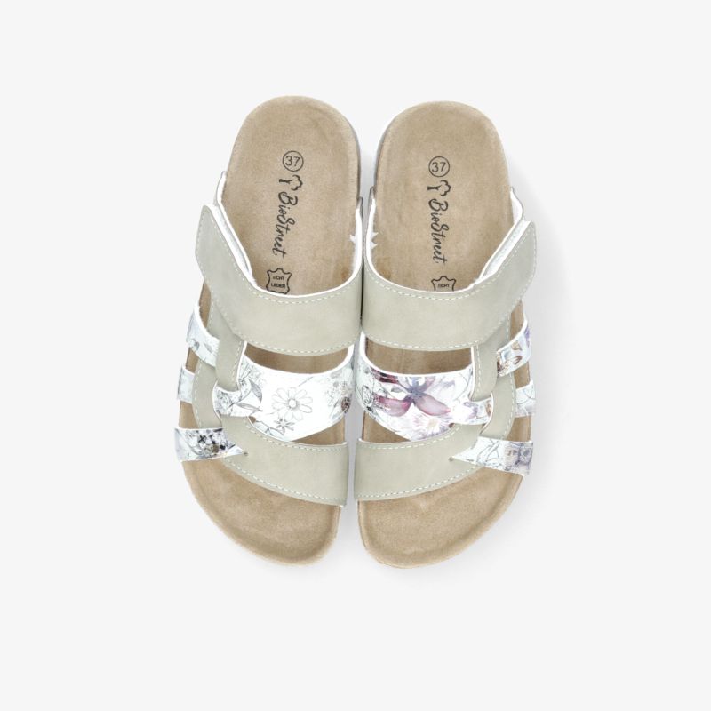 Weißes Paar Sandalen mit verstellbaren Riemen und weichem Fußbett, leicht und bequem für warme Tage