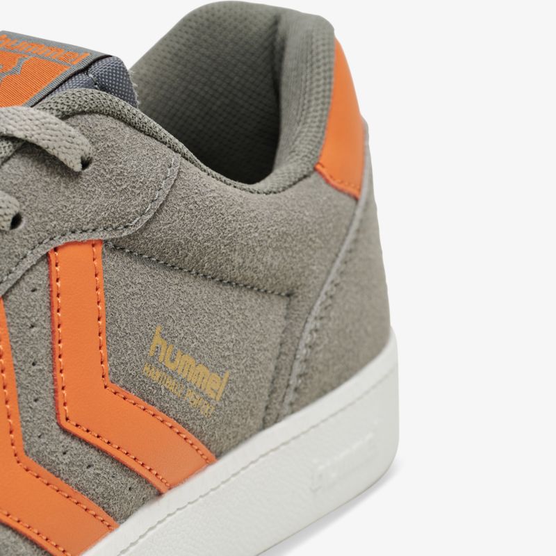Grauer Sneaker mit orangefarbenen Akzenten aus Wildleder, stilvoll und bequem für den täglichen Gebrauch
