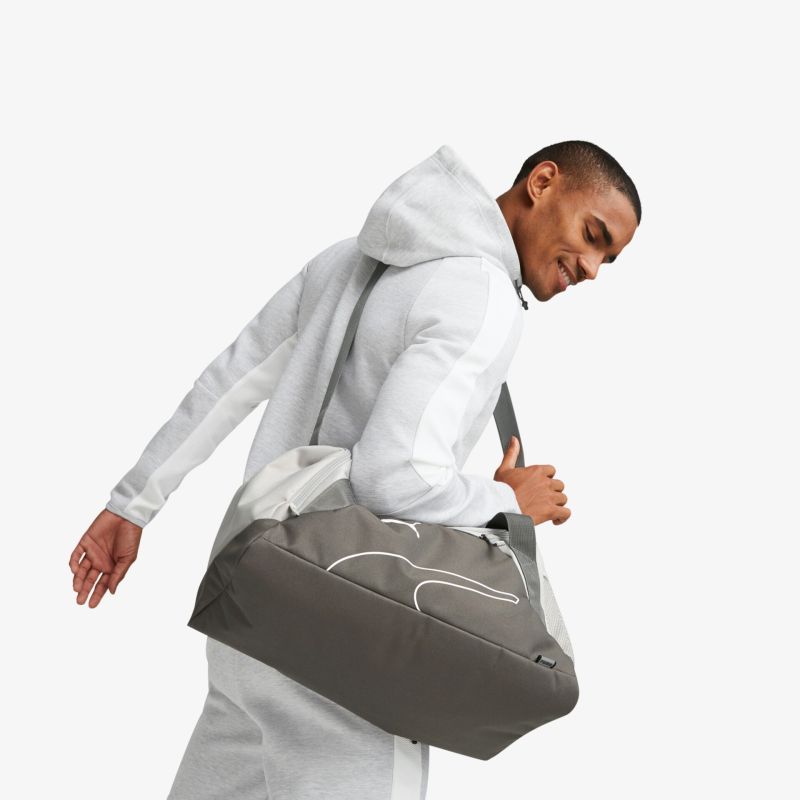 Stylische graue Sporttasche getragen, ideal für Fitness und Reisen, bietet viel Stauraum und Komfort.