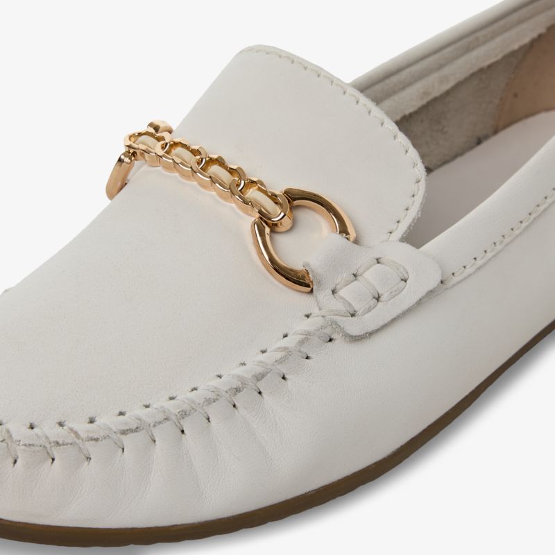Detailaufnahme eines weißen Loafers mit goldener Kettenverzierung und feiner Naht für eleganten Tragekomfort