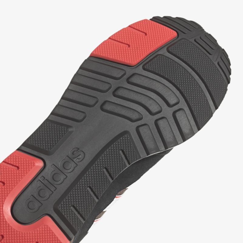 Kraftvolle Laufsohle mit exzellentem Grip und langlebigem Material in sportlichem Schwarz-Rot-Design.